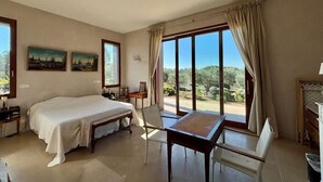 Une chambre à coucher comprenant un lit, une table, une chaise, un bureau et une fenêtre donnant sur l’extérieur.