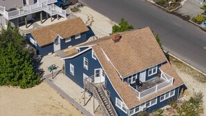 Una casa de dos pisos con balcón, escaleras y entrada para vehículos.