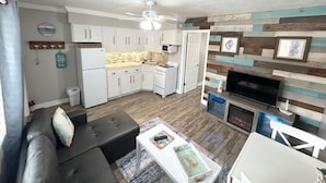 A compact living space with a kitchenette, a fireplace, and a ceiling fan. - Boutique Stay on Clearwater Beach 1BR Suite w/full Kit
Unit 2 (Clearwater Beach)