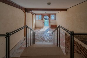 Eine Treppe mit Handlauf führt zu einer Tür mit einem Fenster.