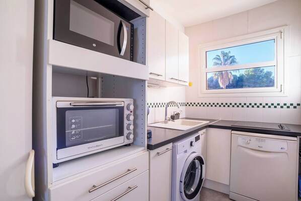 Een magnetron, een oven, een kookplaat, een vaatwasser