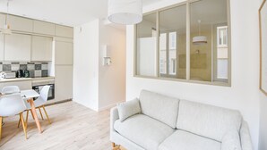 A modern apartment with a kitchen, dining area, and a large window. - Bail mobilité - Appart standing proche Vieux-Port (Marseille)
