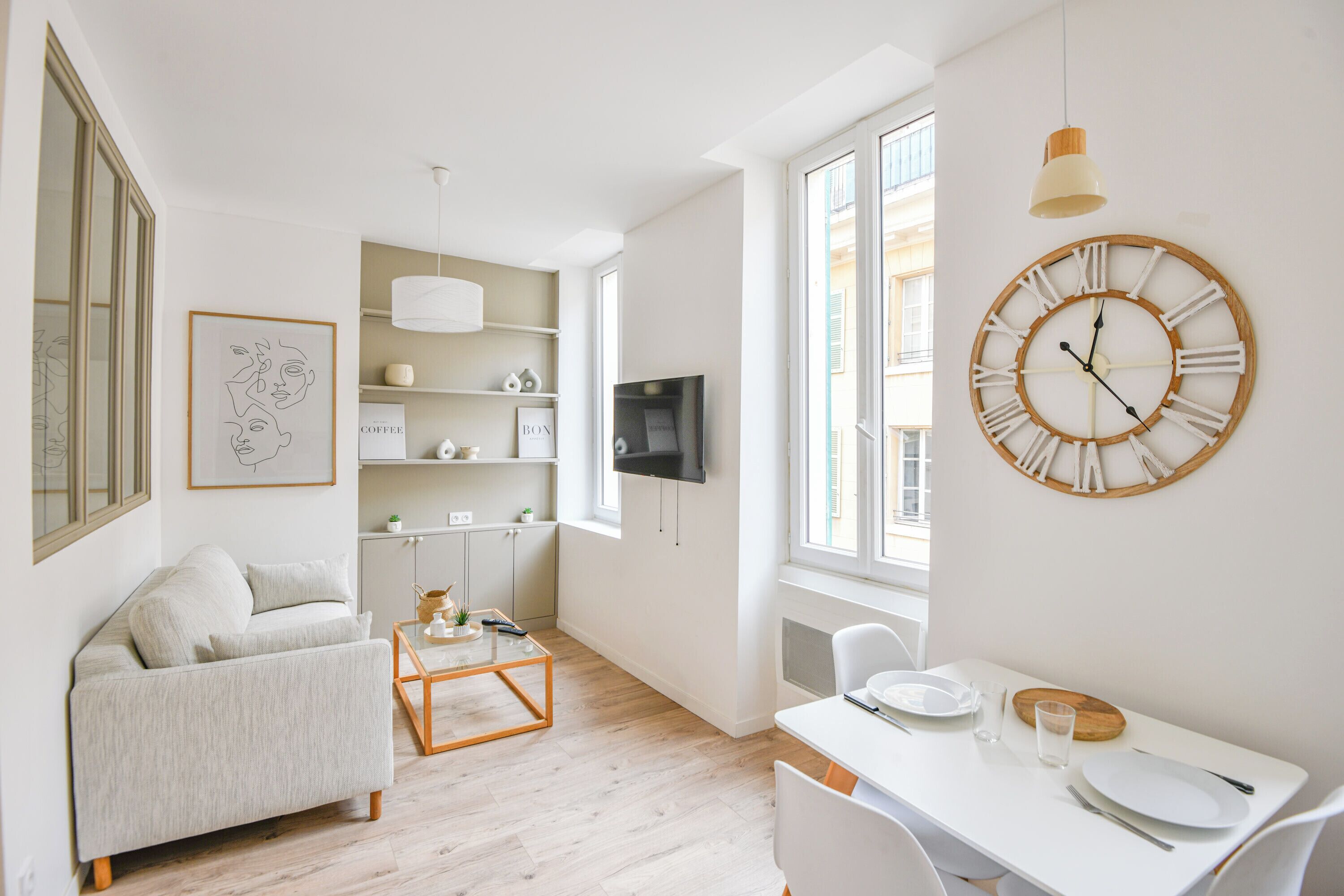 A modern living room with a sofa, coffee table, and a dining area with a table and chairs.