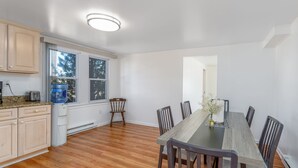 Une cuisine moderne avec des meubles en bois, un four encastré et une grande fenêtre.