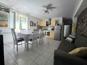 Una cucina moderna con zona pranzo, divano e ventilatore a soffitto.