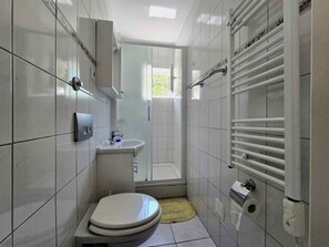 A modern bathroom with a toilet, sink, and shower. - Holiday apartment for 3 people near the beach (Njivice)