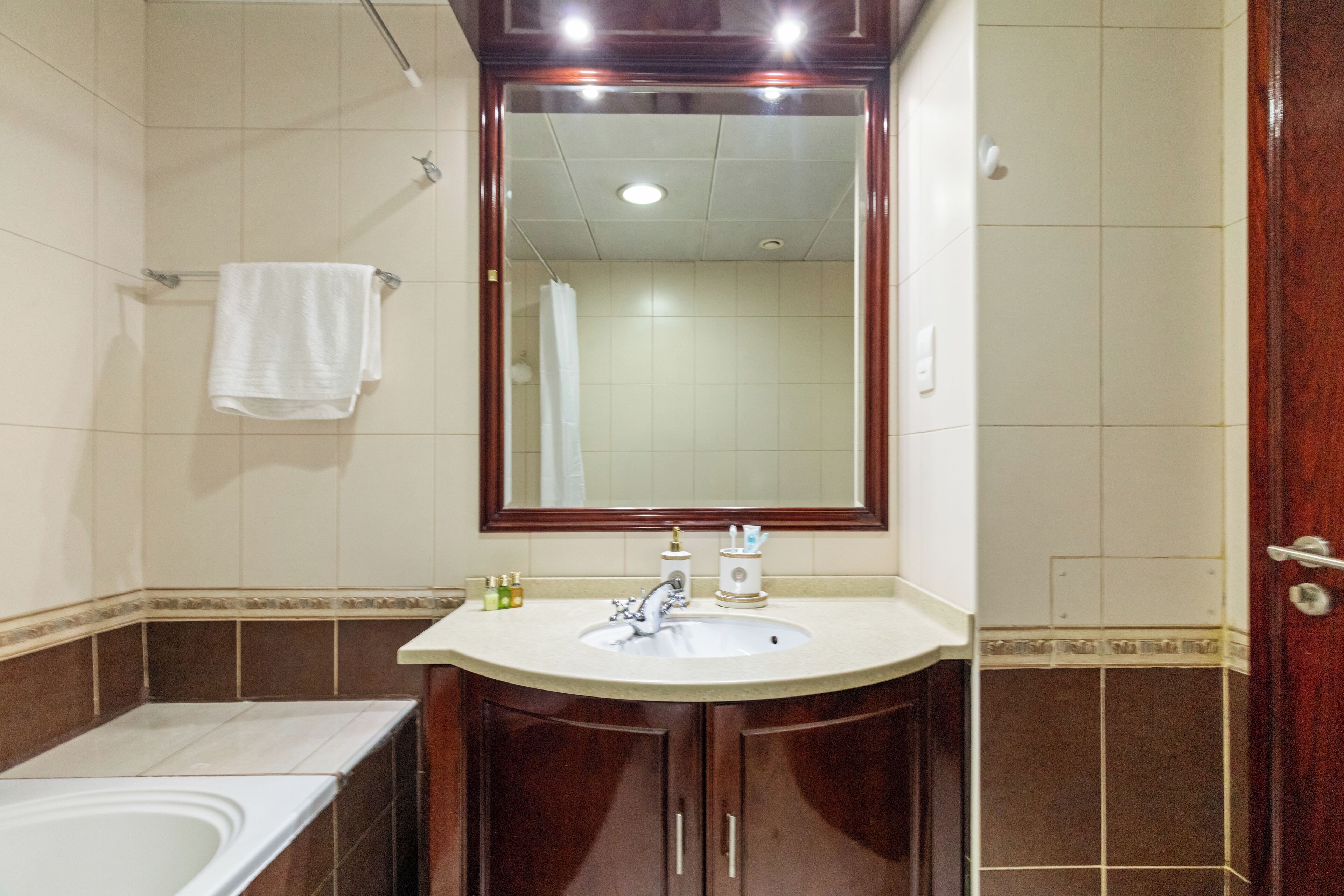 A bathroom with a sink, mirror, and shower.
