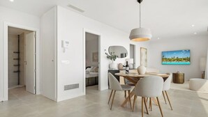 A modern, open-plan living space with a dining area, kitchen, and a shower room. - Higueron Sea View Penthouse 2BR (Fuengirola)