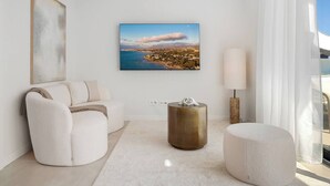 A modern living room with a large window, a sofa, a coffee table, and a painting on the wall. - Higueron Sea View Penthouse 2BR (Fuengirola)