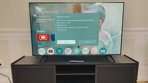 Televisor de pantalla plana sobre un suport negre amb una notificació de actualització de programari.