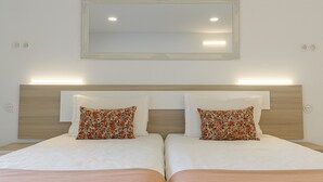 A double bed with matching floral pillows and a night light. - Private Garden - Deluxe Family Apartment (Porto)