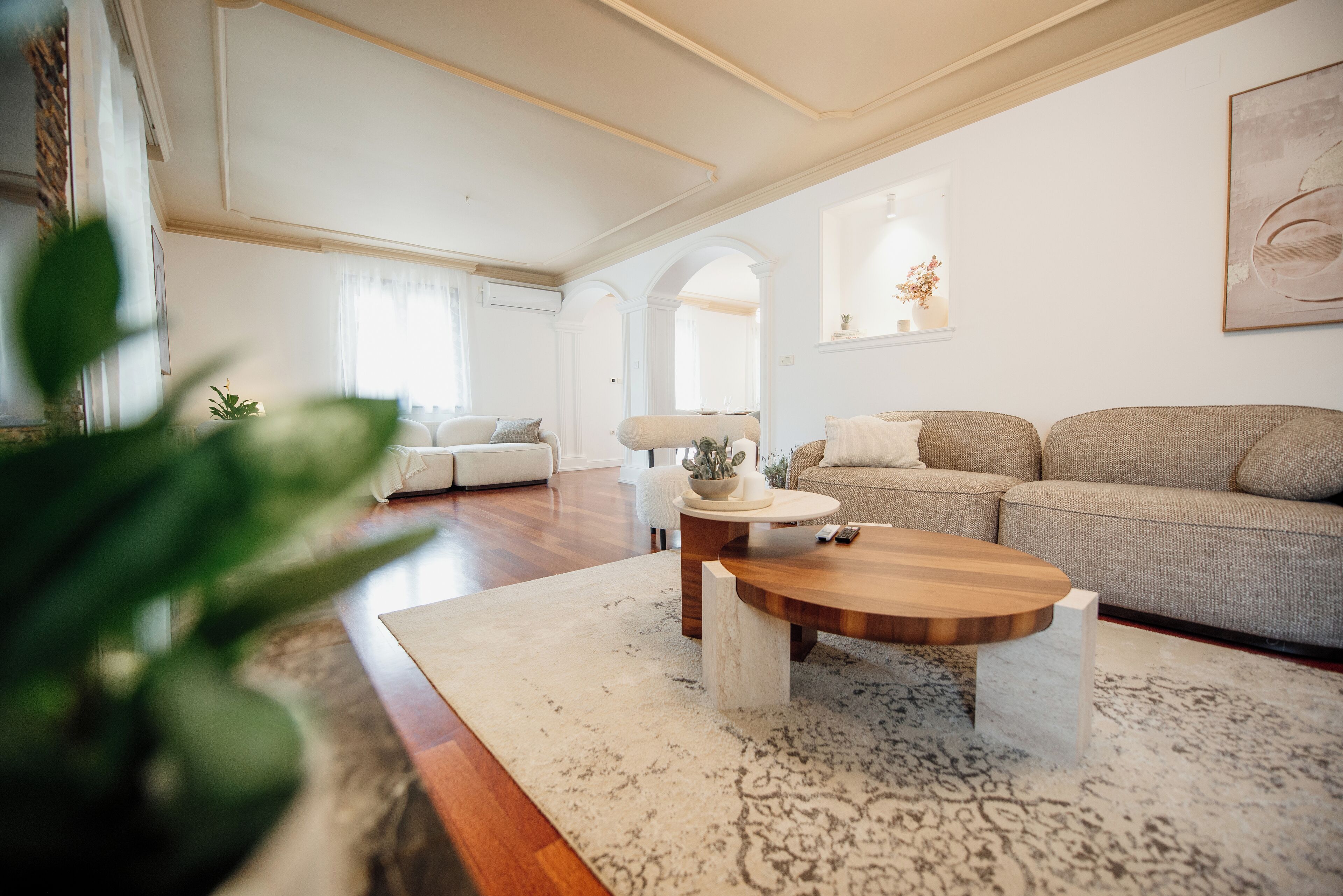 Un salon moderne avec une table basse en bois, deux canapés et un tapis blanc.