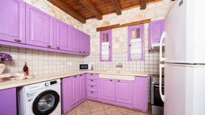 A kitchen with purple cabinets, a washing machine, a microwave, and a refrigerator. - Villa Carolina - Two Bedroom Villa, Sleeps 5 (Agios Dimitrios)