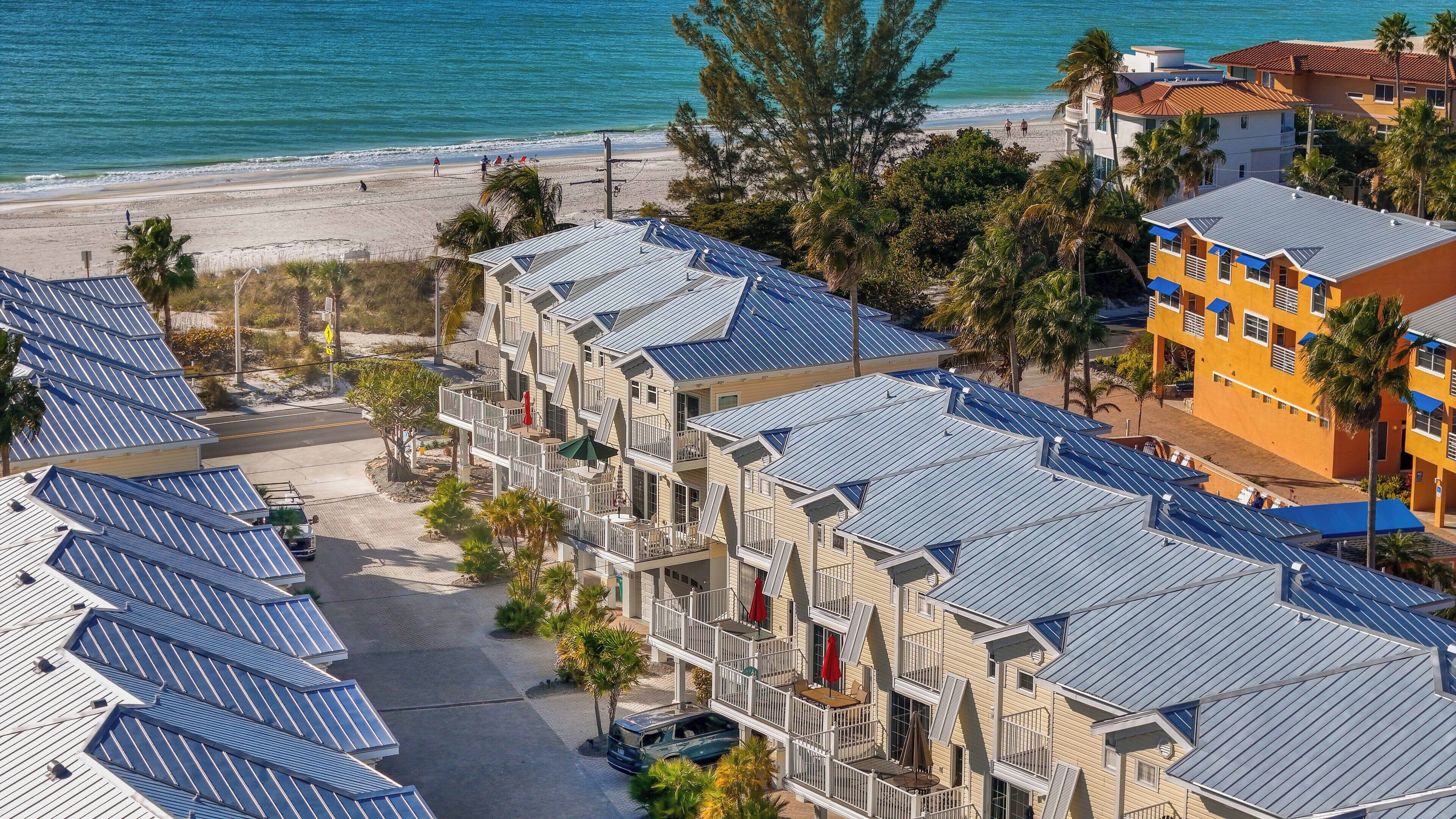 Ein Strandhotel mit mehrstöckigen Gebäuden, Solaranlagen auf den Dächern und Blick auf den Strand.