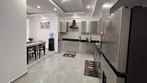 Una cucina moderna con elettrodomestici in acciaio inossidabile, una zona pranzo con tavolo e sedie e un dispenser d'acqua.