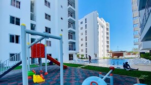 Un'area giochi con altalene, scivoli e un pallone blu.