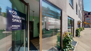 Un edificio con un cartello che indica 'CO Working Space' e 'EINGANG', segnalando un ingresso.