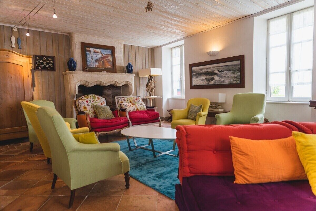 Een gezellige woonkamer met een open haard, comfortabele zitplaatsen en kunstwerken aan de muren.