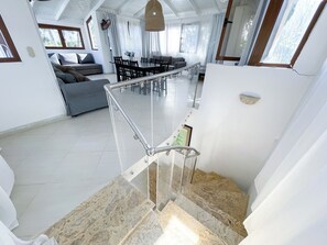 A spacious living area with a staircase leading to a lower level. - KORALES BEACH APARTMENTS (Punta Cana)