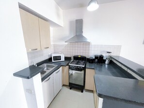 Apartamento superior, 2 habitaciones, terraza, vistas a la piscina | Cocina privada | Frigorífico, microondas, placa de cocina y cafetera o tetera