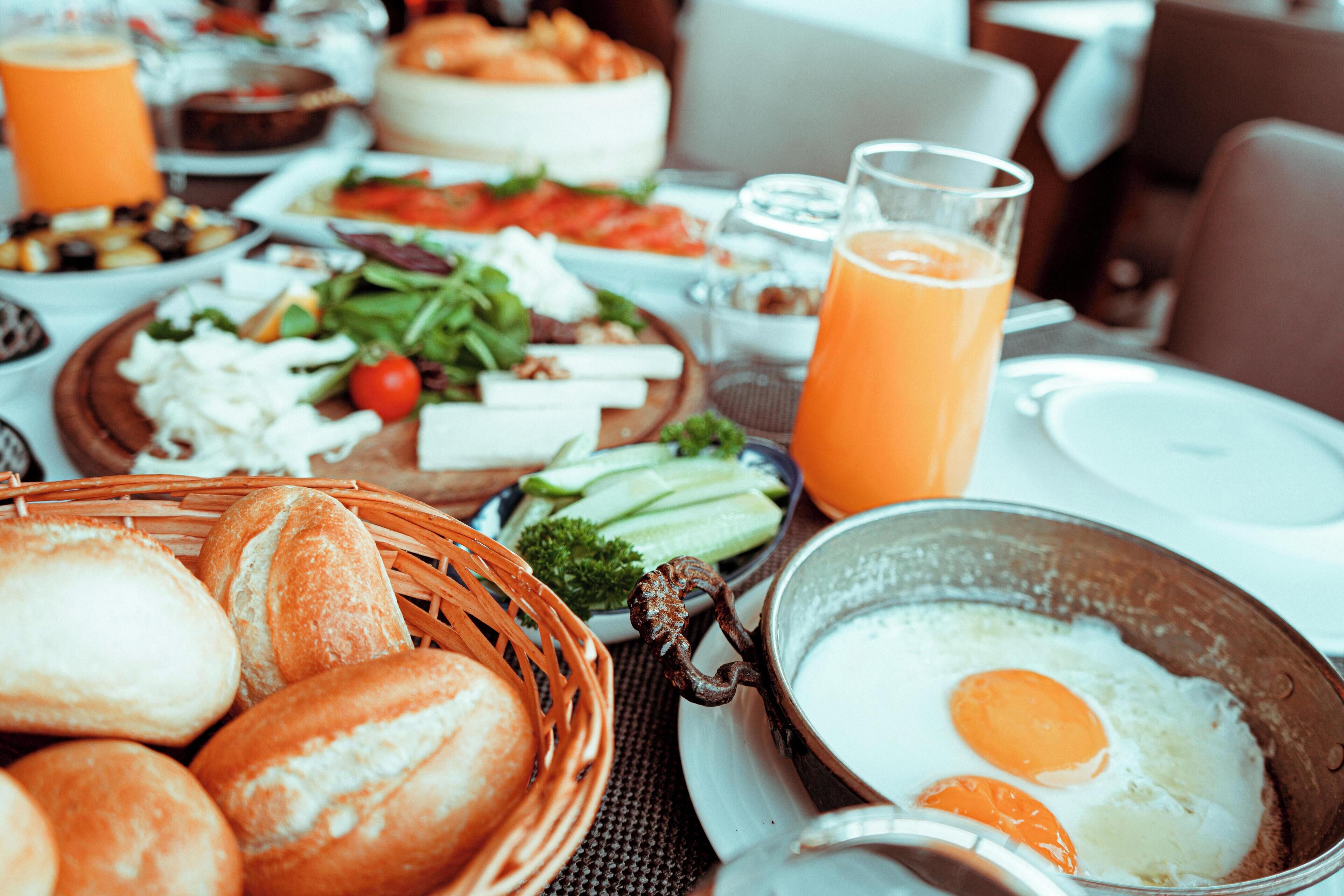 Une table mise pour le petit-déjeuner avec du pain, des œufs et divers plats.