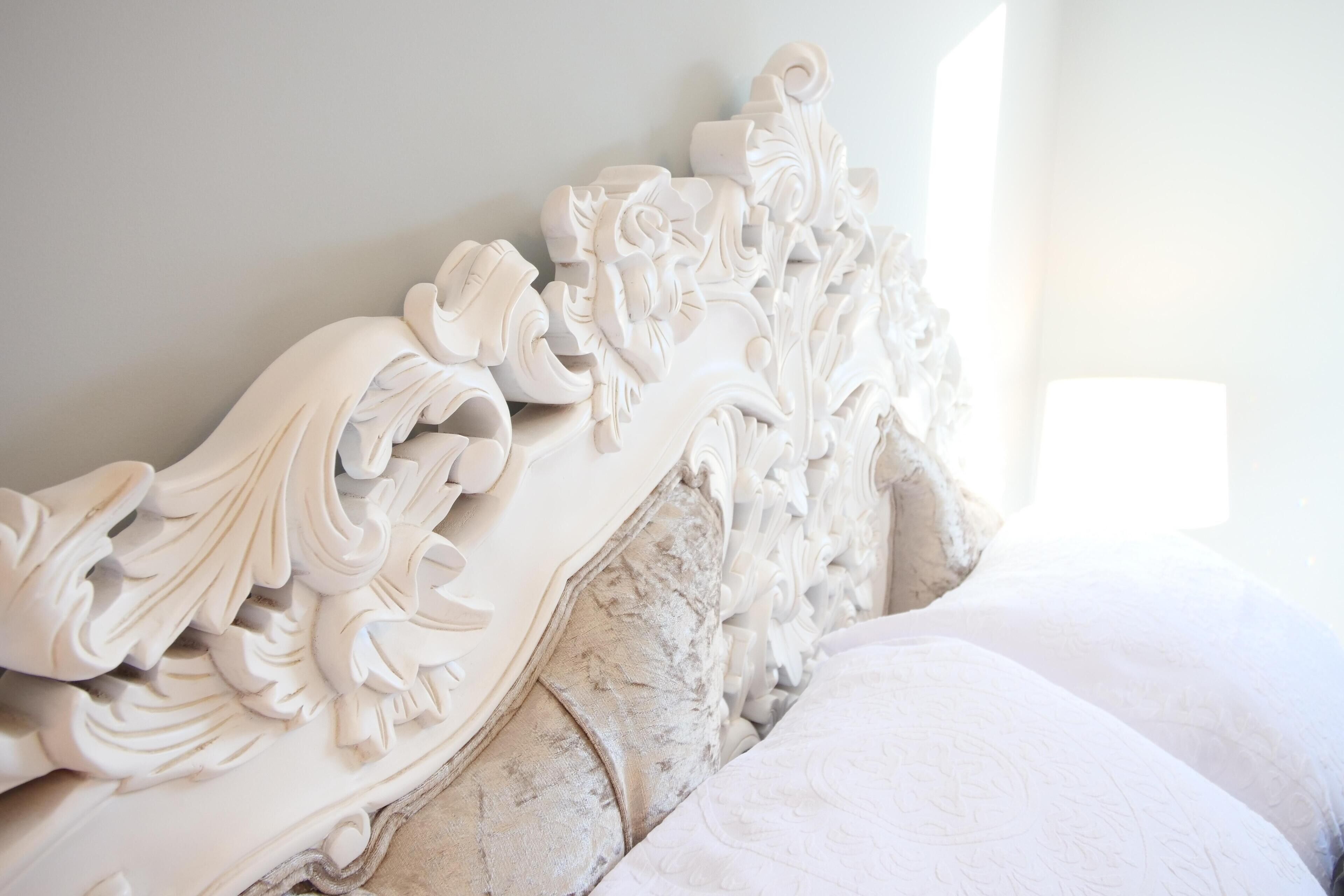 Una cama con una elaborada cabecera decorada con detalles tallados.