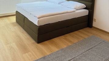 A bedroom with a bed, a skylight, and a radiator.