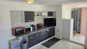 Een moderne keuken met een magnetron, fornuis en koelkast.