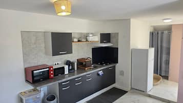 A modern kitchen with a microwave, stove, and refrigerator.