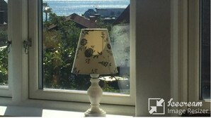 A window with a view of the sea and a lamp on the windowsill. - Newly renovated turn-of-the-century house with sea views (Lysekil)