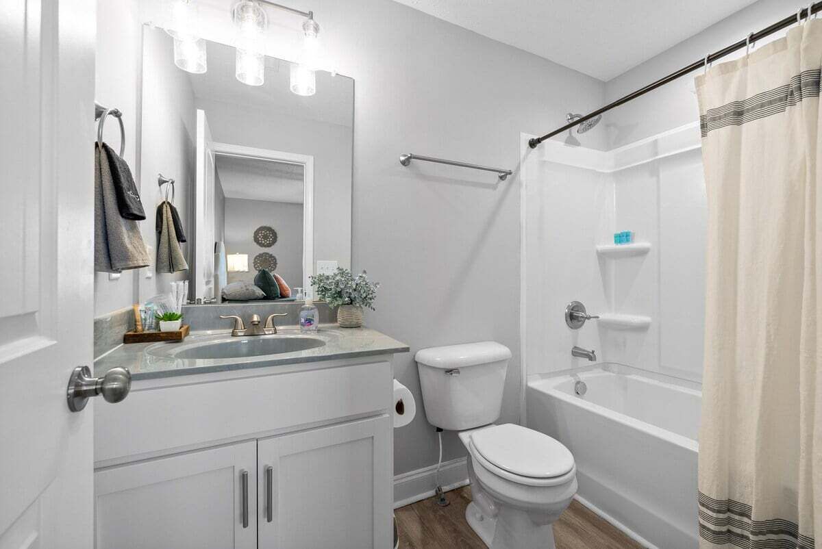 A modern bathroom with a sink, toilet, and bathtub.