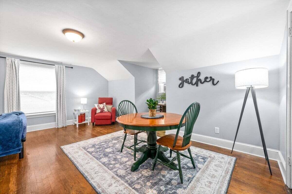A dining area with a round table, chairs, and a rug.