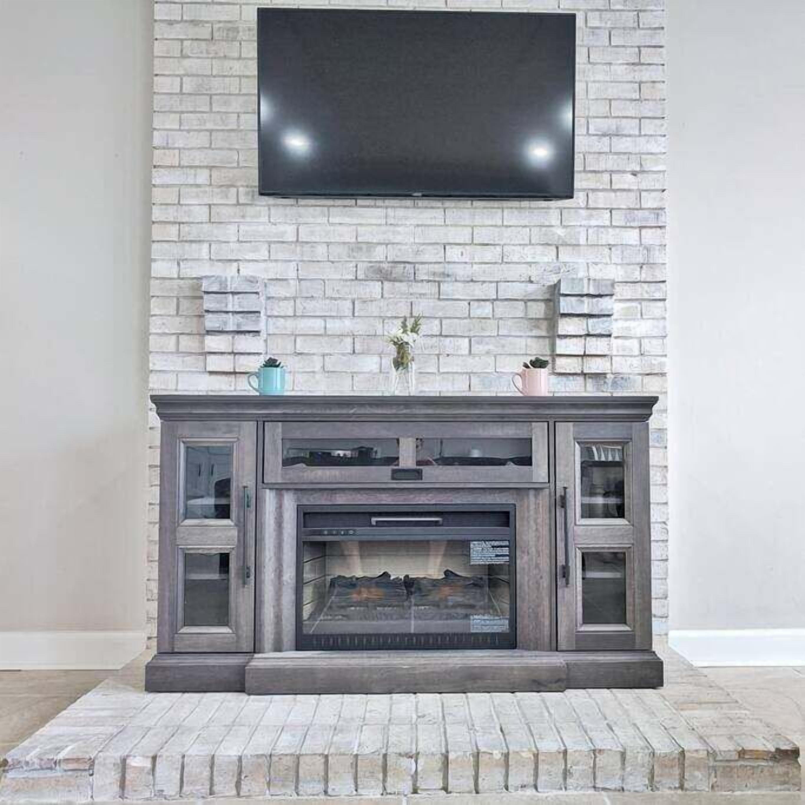 A fireplace with a TV mounted above it, flanked by decorative elements and a brick-patterned wall.