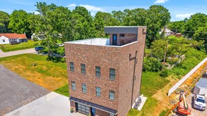 A modern brick building with a flat roof, large windows, and a garage. - The Spot (Clarksville)