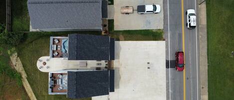 An aerial view of a residential area with two houses, a driveway, and a road.