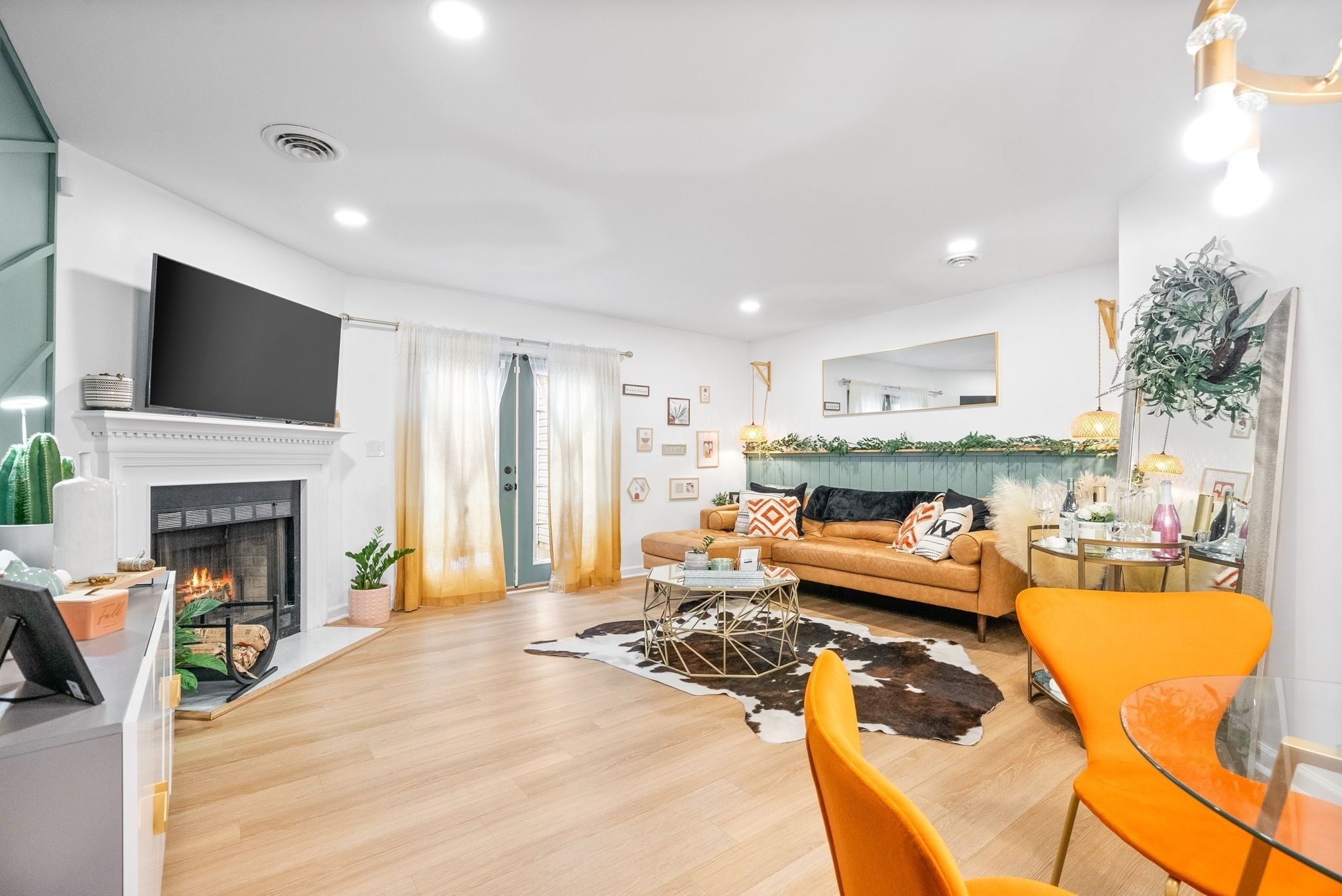 Un salon moderne avec une cheminée, un canapé, une table basse et un téléviseur fixé au mur.