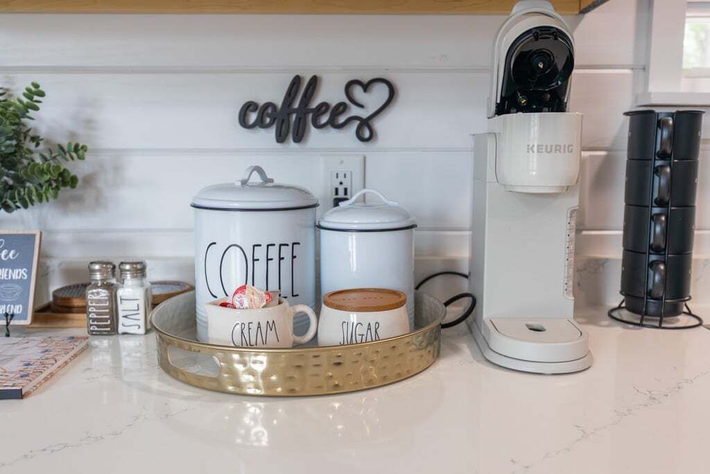 A kitchen counter with coffee-making equipment, including two coffee containers labeled "COFFEE" and a Keurig coffee maker.