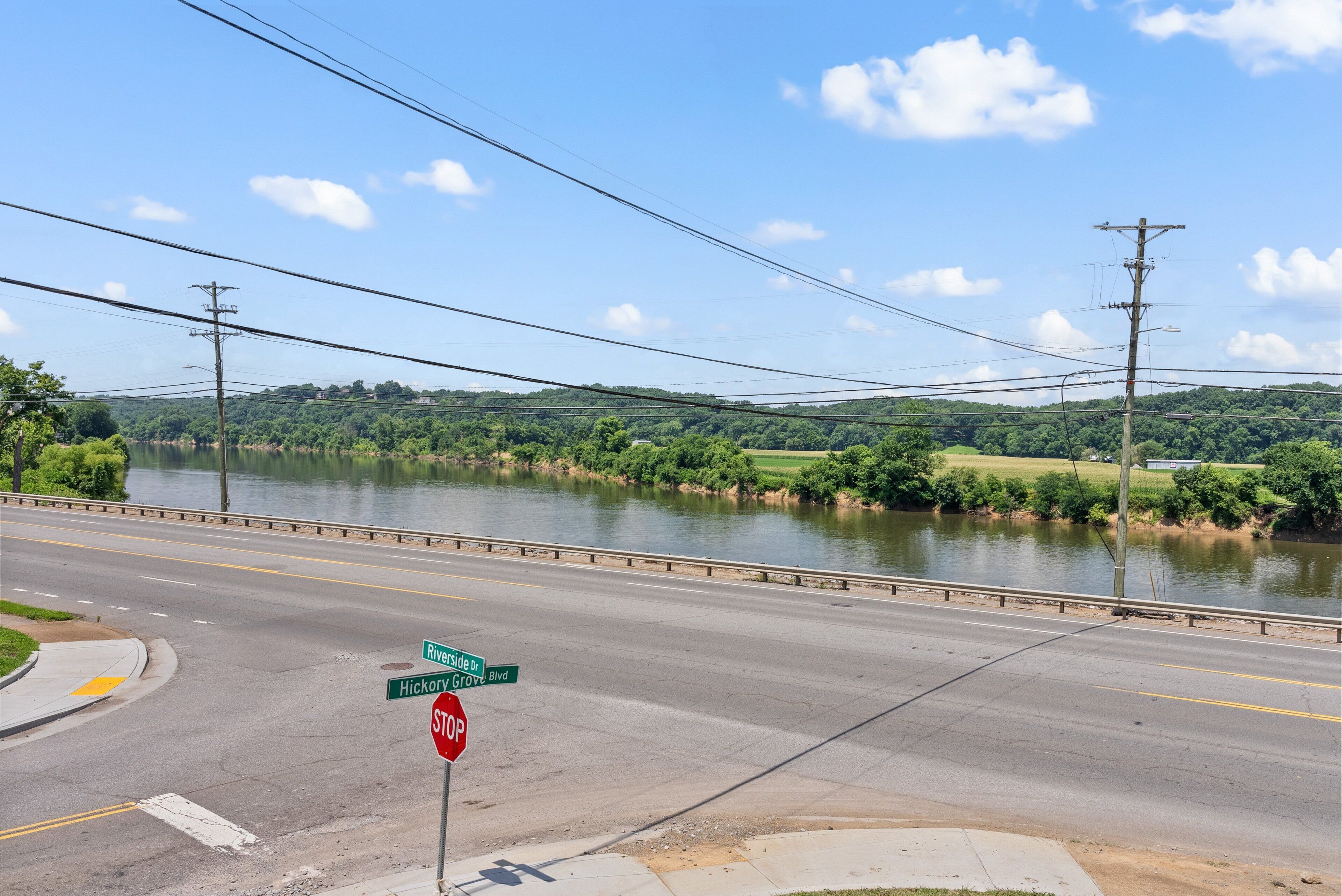 A river with a bridge, a stop sign, and a road intersection.