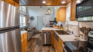 A modern kitchen with wooden cabinets, stainless steel appliances, and a central island. - The Nesting Nook (Dover)