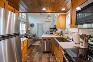 Una cocina moderna con armarios de madera, electrodomésticos de acero inoxidable y una isla central.