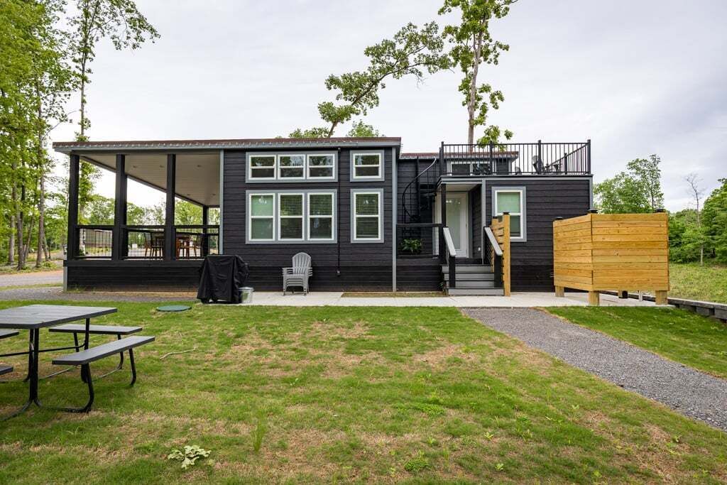 A modern building with a covered outdoor area, a staircase, and a wooden structure.