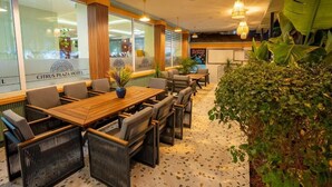 Un moderno vestíbulo de hotel con un mostrador de recepción de madera, asientos cómodos y ventanas grandes.