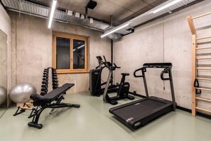 A gym with exercise equipment, a window, and a wooden ladder. - Ibis Styles Bern City (Berne)