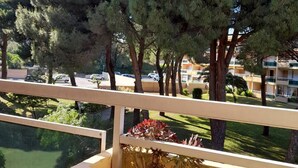 Ein Balkon mit Blick auf einen Parkplatz und ein mehrstöckiges Gebäude.