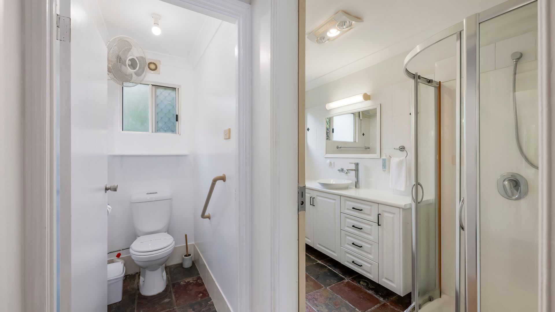 Een moderne badkamer met toilet, douche en hygiëneschuimer.