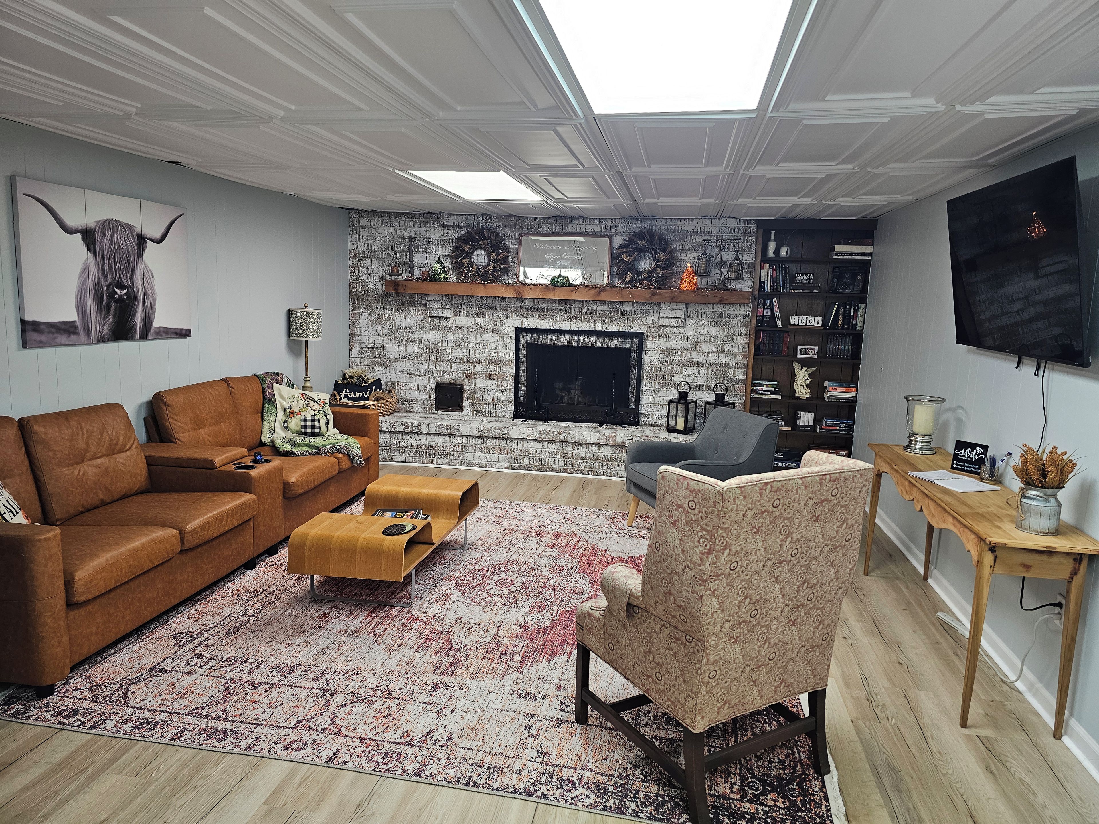 Una sala de estar con chimenea, un sofá, una mesa de centro y un televisor.