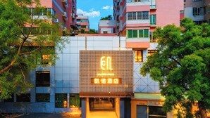 A hotel entrance with a digital sign displaying the name and logo.