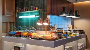 A buffet setup with various food items, a microwave, and hanging pendant lights. - Kainuo Garden Aesthetic Design Hotel - Guangzhou Yuexiu Beijing Road, International Clothing City Trade Centre Store (Guangzhou)