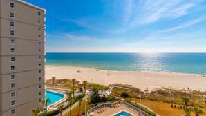 Un hotel con piscina, vista a la playa y cielo despejado.