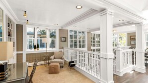 A spacious room with a high ceiling, large windows, and a white railing. - West End Splendor by Snowmass Vacations (Aspen)